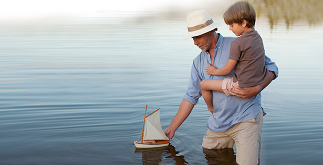 Gewässerschadenhaftpflicht - Mann mit Kind lassen ein Boot in den See