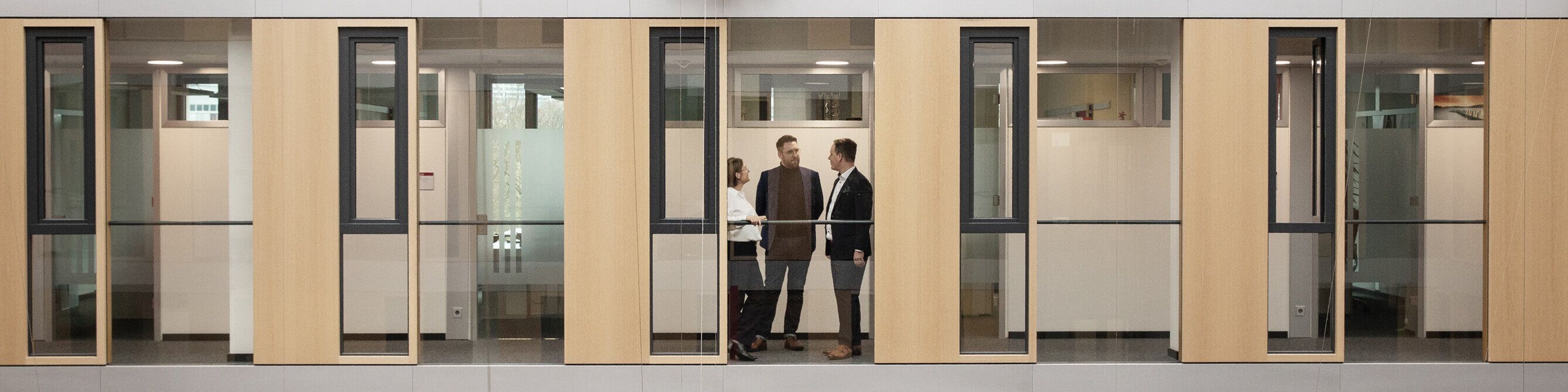 Drei Mitarbeiter der SV tauschen sich im Flur aus