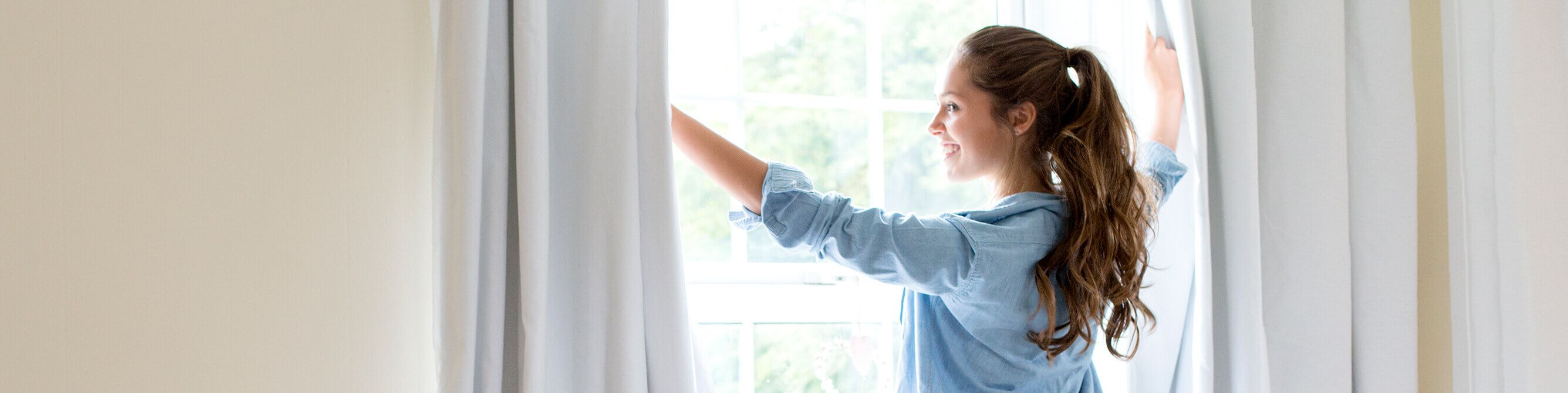 Kundin der SV SparkassenVersicherung öffnet Fenster zum Lüften