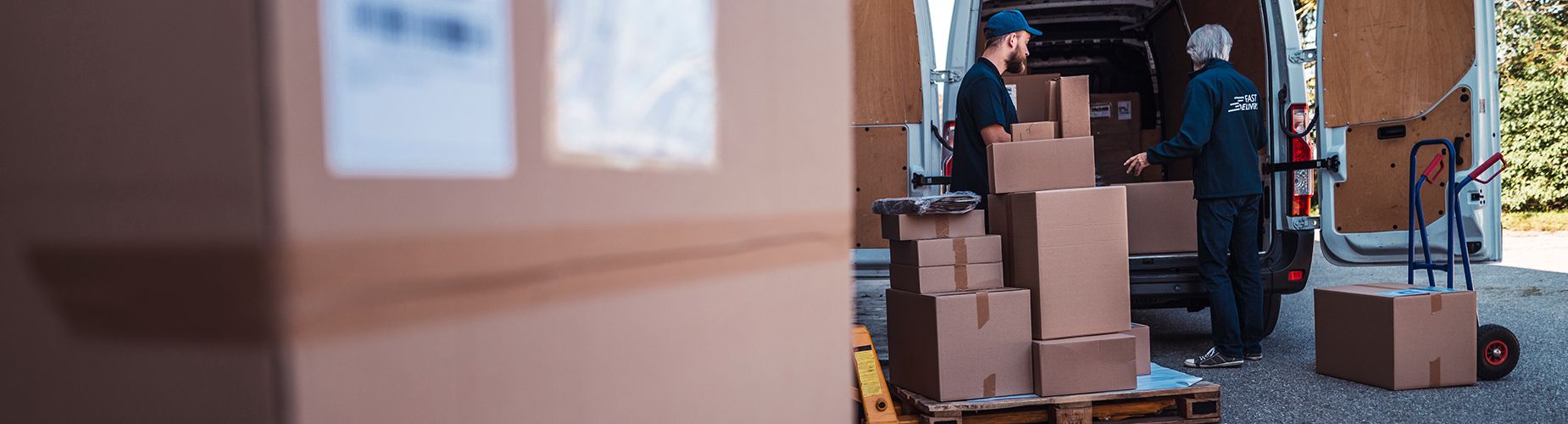 Männer beladen Transporter und checken Pakete