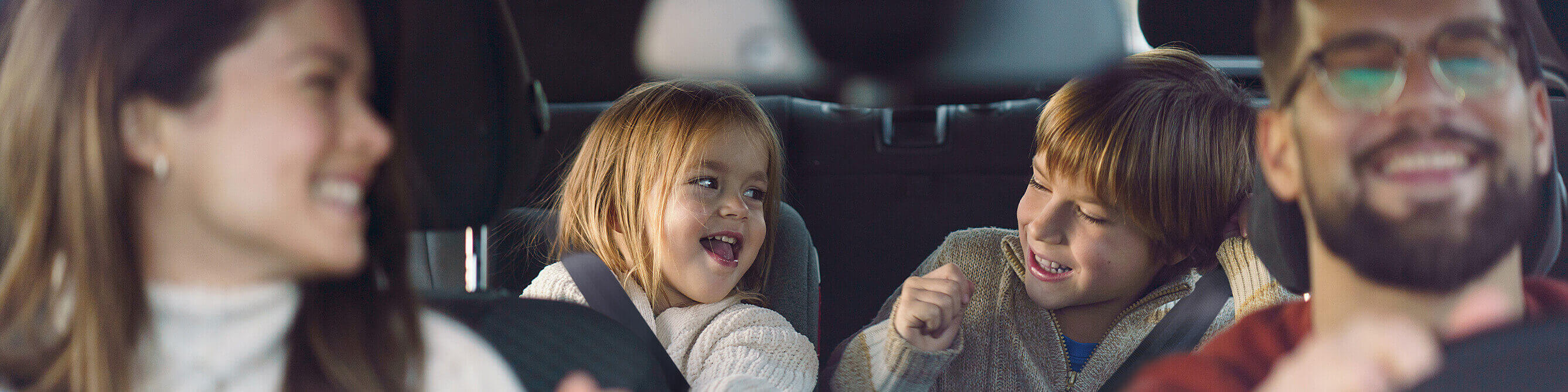  Kunden der SV SparkassenVersicherung fahren entspannt mit ihren Kindern im Auto