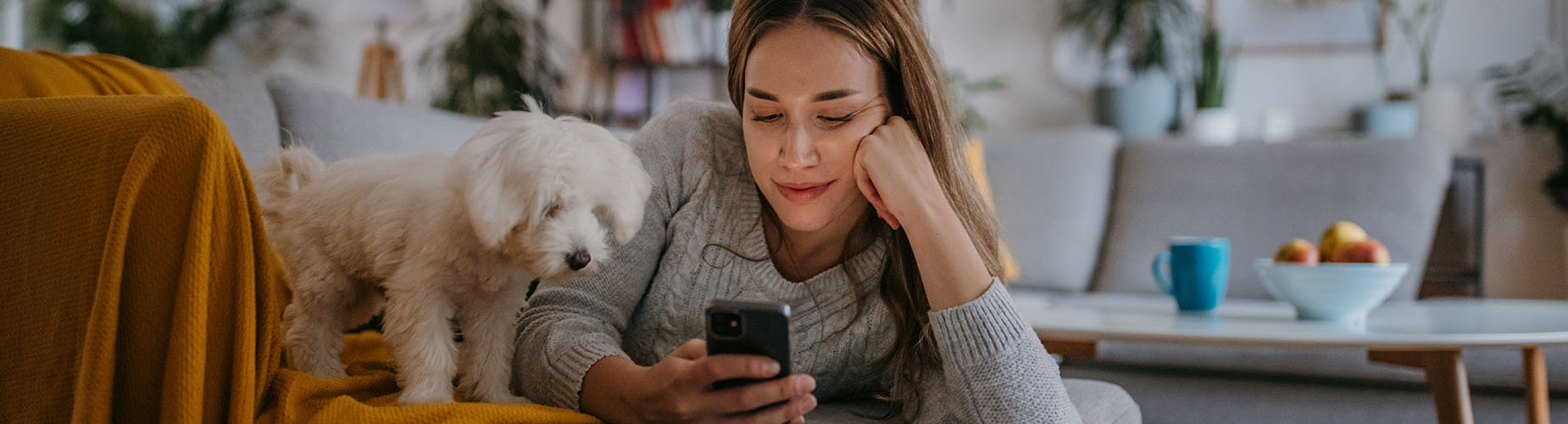 Newsletter-Abmeldung, Frau am Handy mit Hund auf der Couch