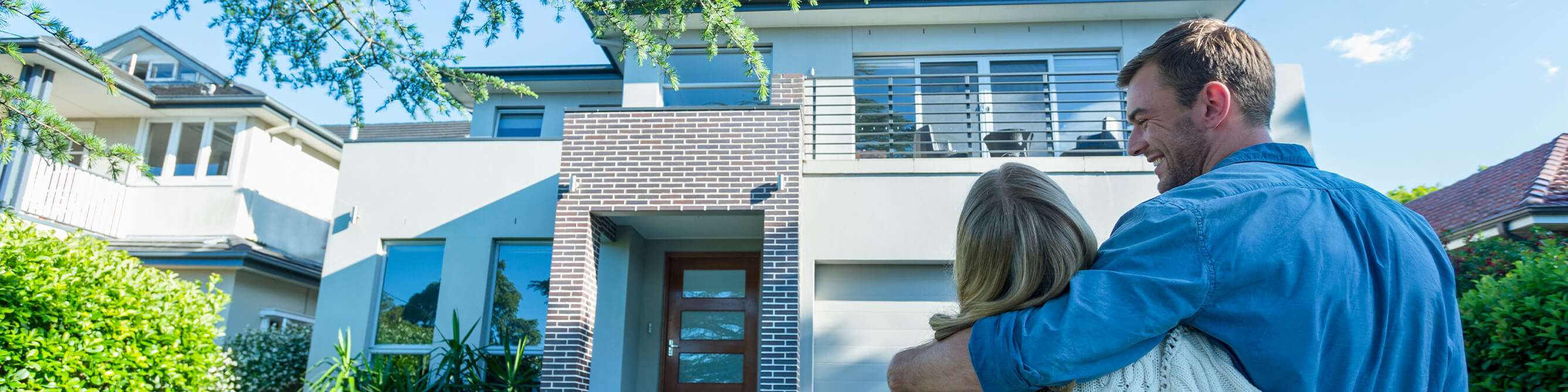 Paar steht vor dem Eigenheim