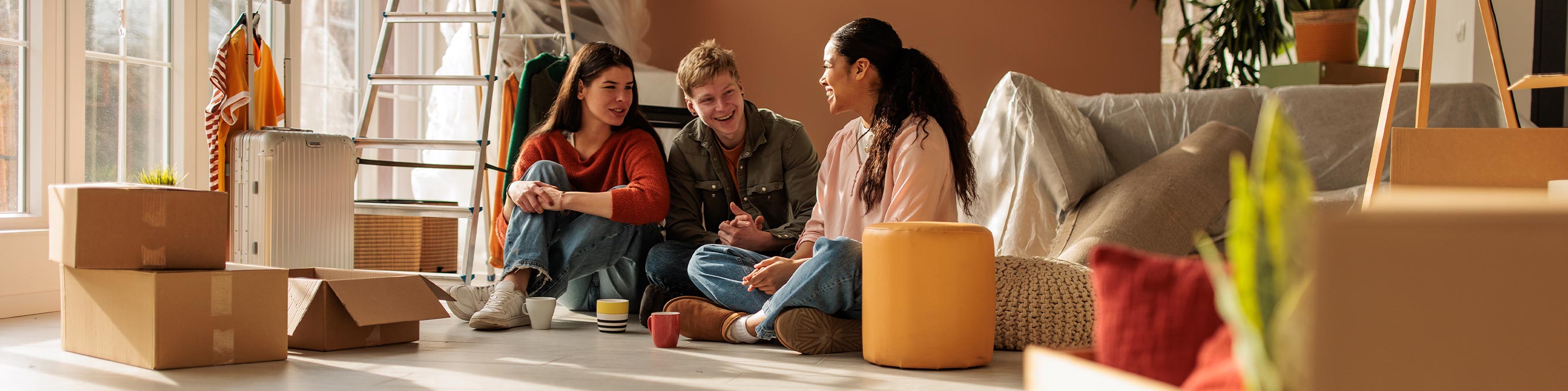 Junge Leute sitzen in Wohnung auf dem Boden