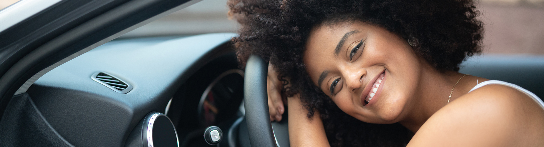 lächelnde Frau am Steuer eines Autos