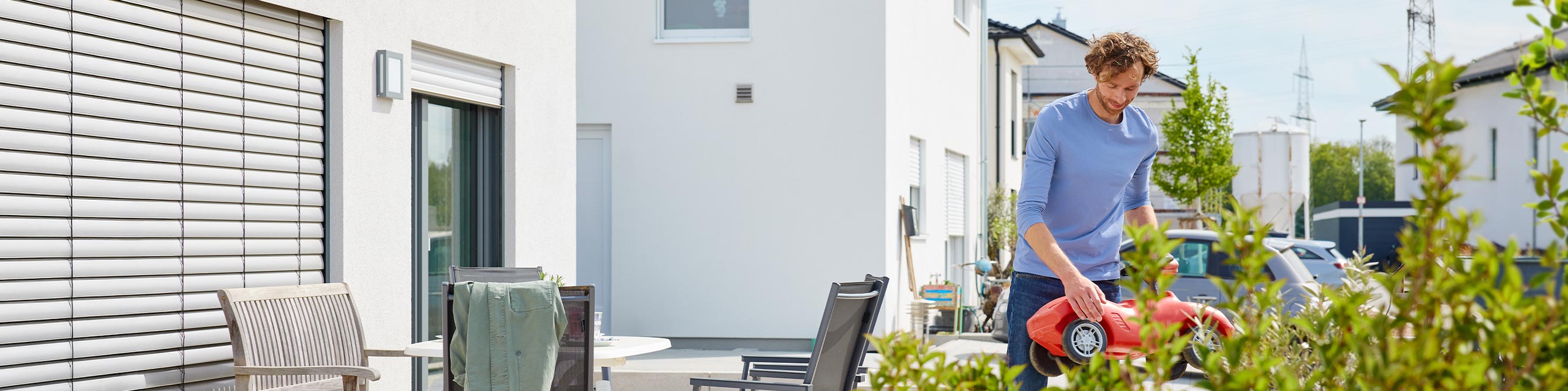 Vater steht vor seinem Neubau