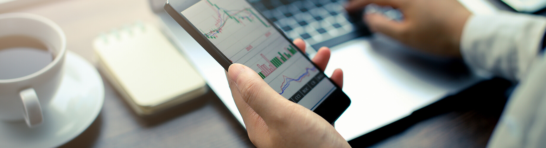 Mann schaut nach Kursveränderungen auf dem Smartphone