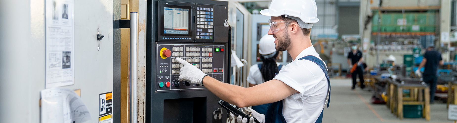 Mitarbeiter in Lagerhalle programmiert Maschine