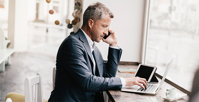 Unternehmer mit Kaffee vor PC