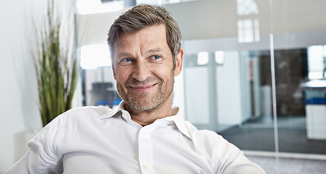 Mann lehnt auf Stuhl im Büro