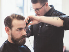 Mann beim Haare schneiden 