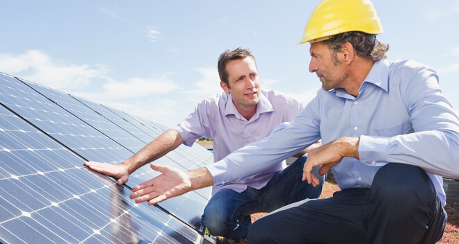 Männer überprüfen eine Photovoltaikanlage