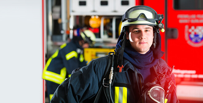 Feuerwehrmann vor Feuerwehrwagen