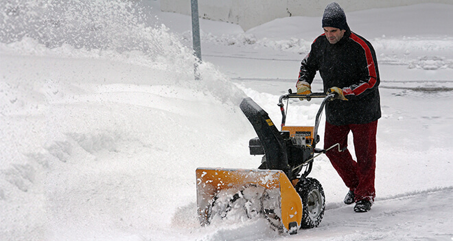 Mann beim Schneeschippen