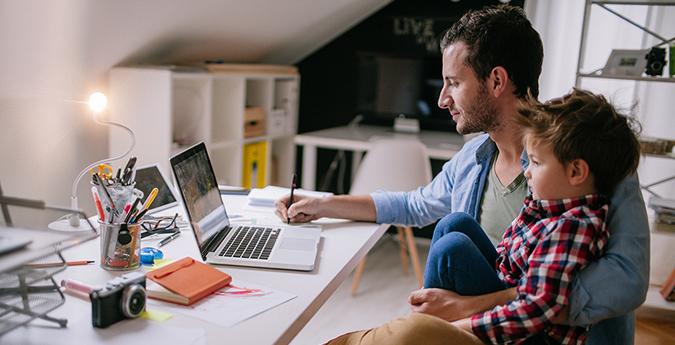 Vereinbarkeit Beruf und Familie - Vater mit Kind im Homeoffice