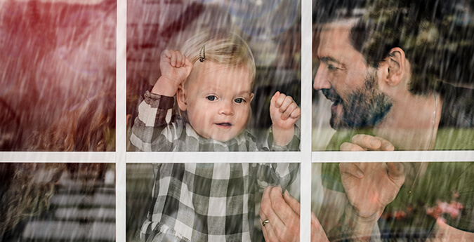 Mann mit Kind am Fenster