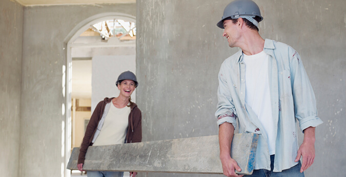 Bauherren-Haftpflichtversicherung - zwei Bauarbeiter tragen Balken