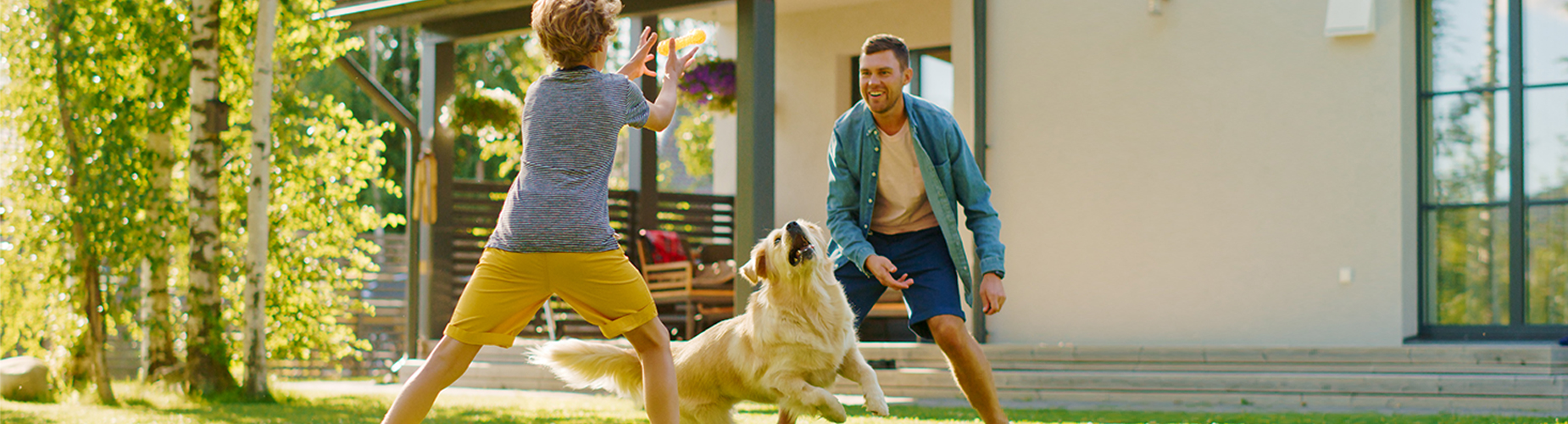 Haus-­ und Grundbesitzerhaftpflicht - Vater und Sohn spielen mit Hund