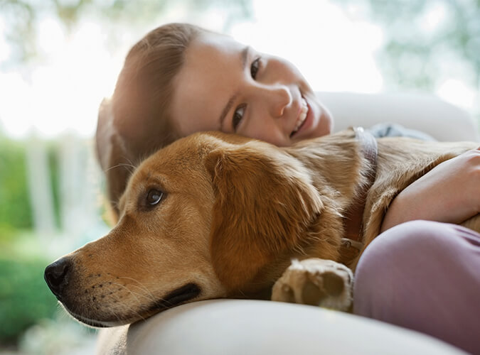 Tierhalterhaftpflicht - Mädchen mit Hund im Arm
