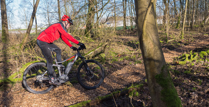 E-BikeSchutz - Fahrradfahrer fährt durch den Wald