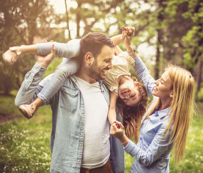 Risikolebensversicherung - Familie spielt im Wald