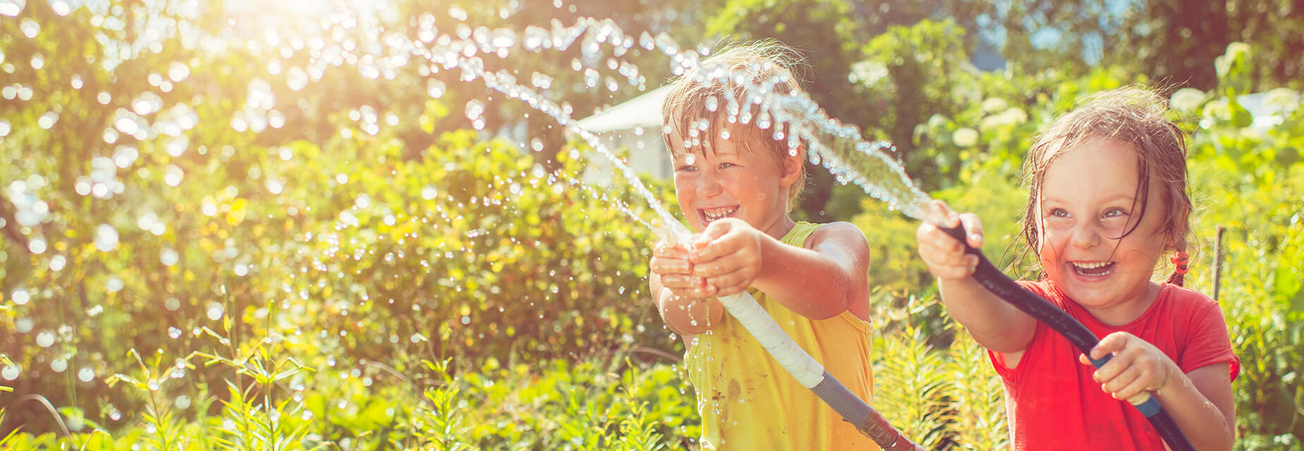 Kinder mit Gartenschlauch