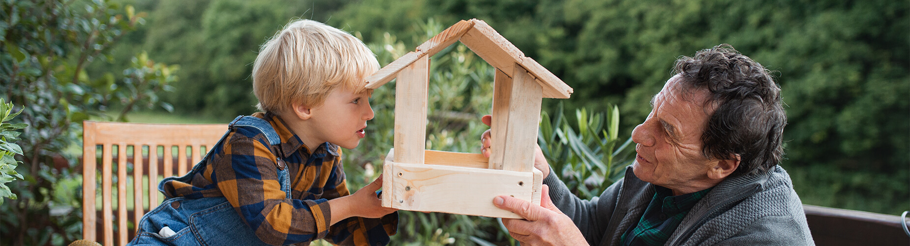 Mann und Kind halten Vogelhaus