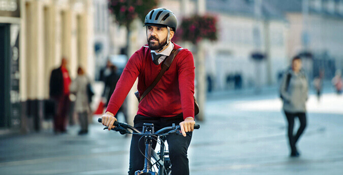 Mann fährt mit E-Bike in einer Fußgängerzone