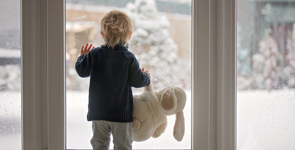 Kind schaut aus dem Fenster