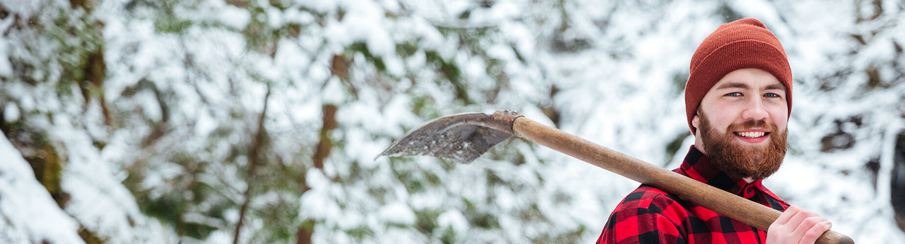 Mann mit Schneeschaufel in der Hand