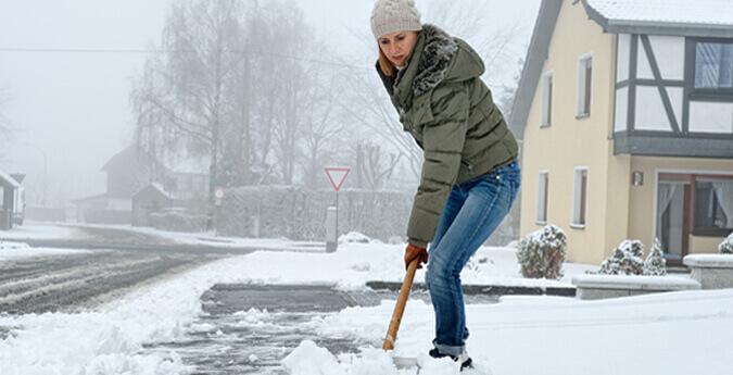 Frau schippt Schnee