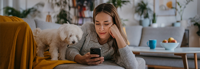 Frau mit Hund auf der Couch – Newsletter der SV SparkassenVersicherung